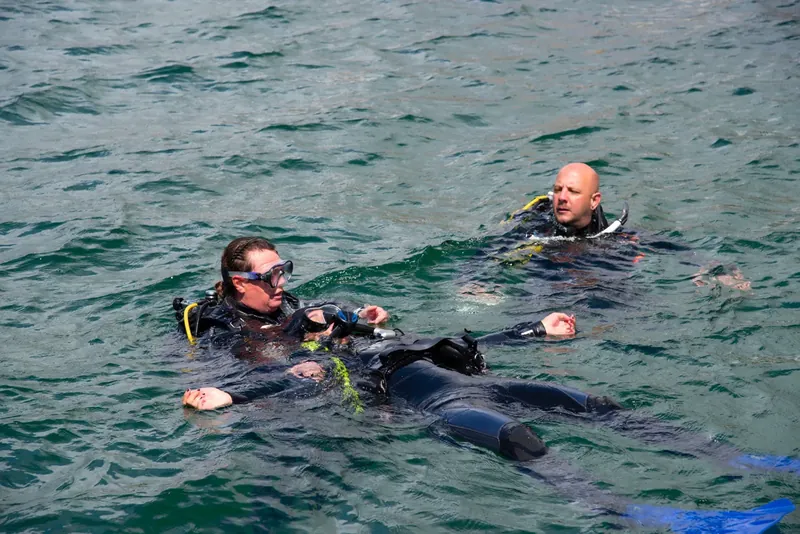 Búvárok a vízfelszínen sötét ruhában – PADI Dry Suit Diver